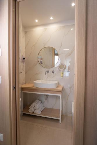 ein Badezimmer mit Waschbecken und Spiegel in der Unterkunft Hotel Paistos Paestum in Paestum