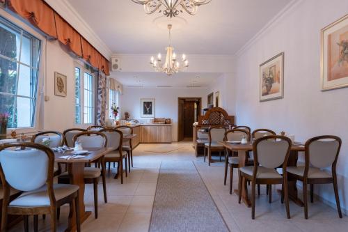a dining room with tables and chairs and a chandelier at Rixbecker Alpen - Hotel Koch in Lippstadt