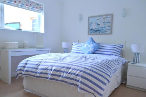 a bedroom with a bed with blue and white stripes at Manor House Apartment 2 in Shaldon