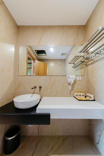 a bathroom with a white sink and a mirror at Paradise Bay Hotel - Vinhomes Ocean Park 3 in Ðình Loan