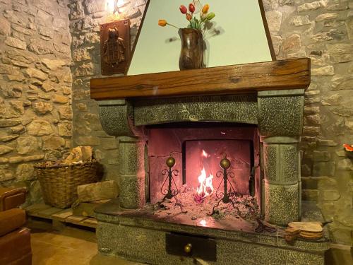 a stone fireplace in a room with a vase on top at Casa Rural Masión de Egüés in Elcano