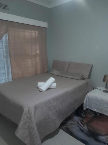 a bed with two white towels on top of it at Uptown Inn GuestHouse in Parys
