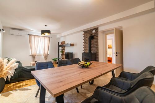 ein Wohnzimmer mit einem Holztisch und Stühlen in der Unterkunft Holiday house Solis in Rab