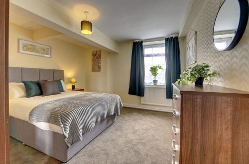 a bedroom with a large bed and a window at 5 bedrooms, sleeps up to 16, secure parking space & comfort in Skegby