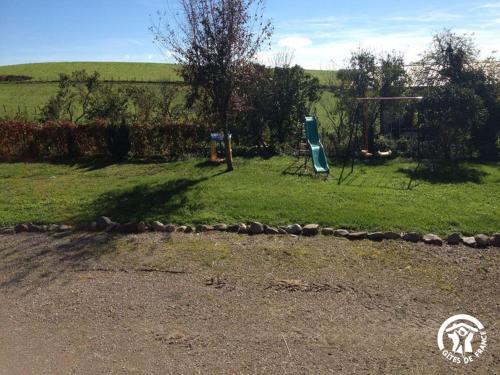 a park with a playground with a swing at Gîte à la Ferme in Las Pelies