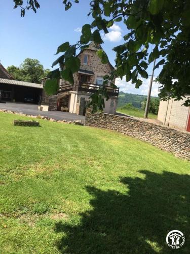 a house on a hill with a green lawn at Gîte à la Ferme in Las Pelies