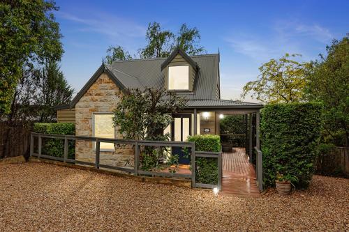 a house with a wooden fence in front of it at Two Truffles Cottage Accommodation in Yarra Glen