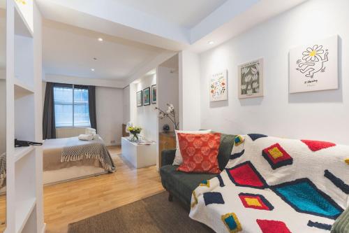 a living room with a couch and a bed at Compact & Bijou Chelsea Studio in London