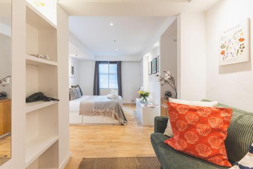 a living room with a couch and a bed at Compact & Bijou Chelsea Studio in London
