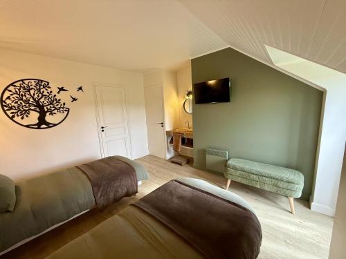 ein Schlafzimmer mit einem Bett und einem Stuhl und einem Baum an der Wand in der Unterkunft Des puits in Locoal-Mendon