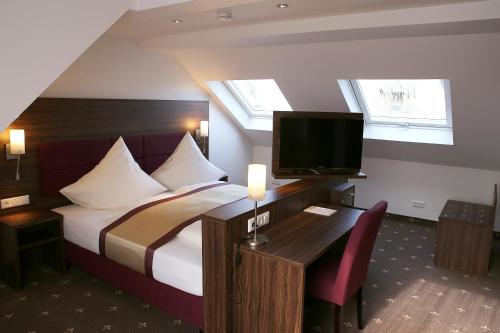 ein Hotelzimmer mit einem Bett und einem TV in der Unterkunft Hotel Rothkamp in Frechen
