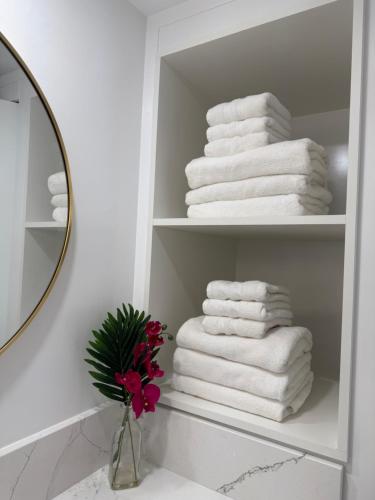 ホノルルにあるNewly renovated luxury, modern style Waikiki Sunset Hotel Ocean view Freeparkingの浴室の棚に積み重ねられたタオル