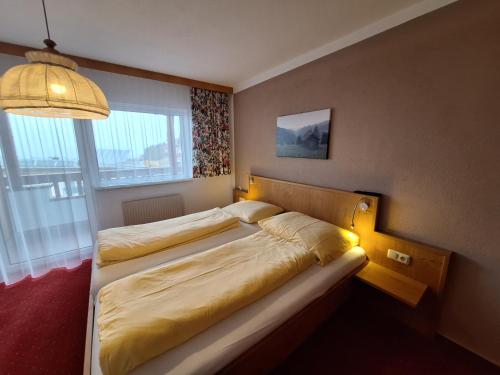 ein Schlafzimmer mit zwei Betten und einem großen Fenster in der Unterkunft Appartements Rosmarie in Fendels