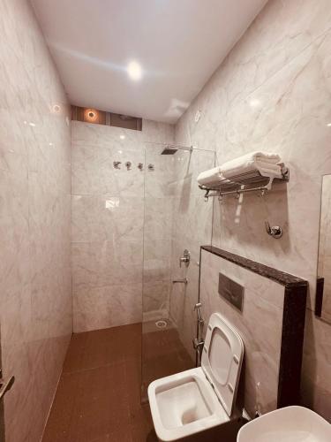a bathroom with a toilet and a glass shower at Hotel Mumbai House Pithampur in Mhow