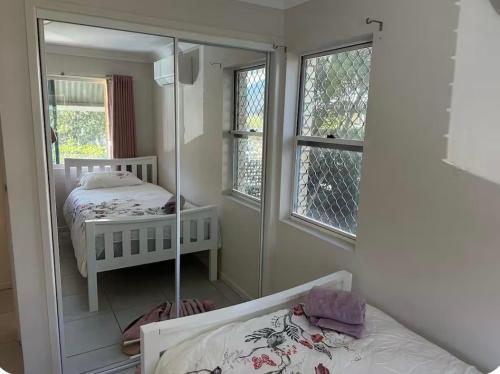 een slaapkamer met een spiegel en een bed erin bij UQ single bedroom with pool Q2 in Brisbane