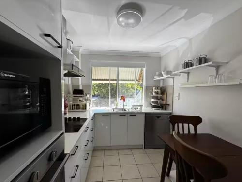een grote witte keuken met een tafel en een eetkamer bij UQ single bedroom with pool Q2 in Brisbane