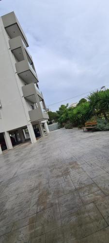 a large building with a bench next to the ocean at Eleusis Luxury Flat,car park in property in Elefsina