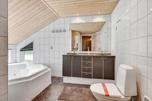 a bathroom with a tub and a toilet and a sink at HS013-Oksbol-Hybenvangen-6 in Oksbøl