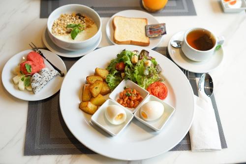 una mesa con platos de comida y tazas de té en Beverly Mountain Bay, Trademark Collection by Wyndham, en Pattaya South