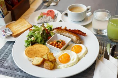 un plato de desayuno con huevos, patatas con tocino y tostadas en Beverly Mountain Bay, Trademark Collection by Wyndham, en Pattaya South