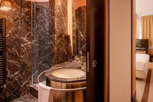 a bathroom with a sink and a shower at UNA Hotels Malpensa in Cerro Maggiore