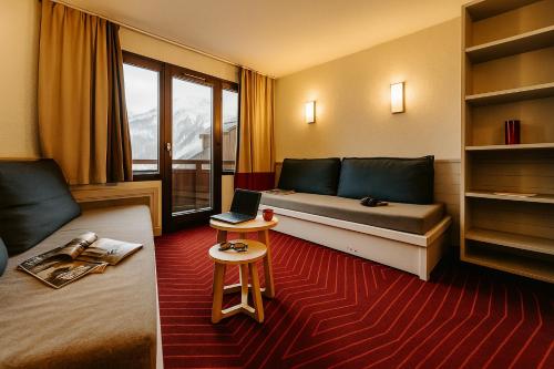 a room with a bed and a laptop on a table at Résidence La Daille - Val-d'Isère in Val dʼIsère