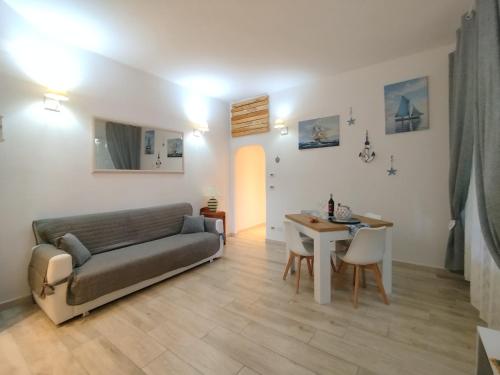 a living room with a couch and a table at Appartamento al parco con parcheggio gratuito in Orbetello