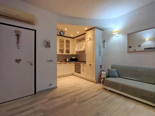 a living room with a couch and a kitchen at Appartamento al parco con parcheggio gratuito in Orbetello