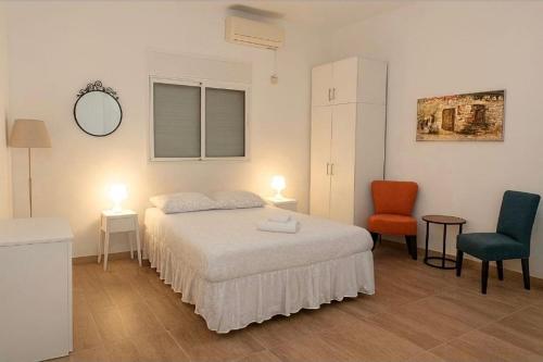 a bedroom with a bed and two chairs in it at Paradise in haifa near the bahai gardens in Haifa
