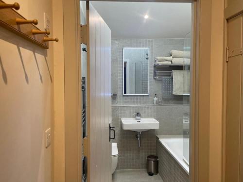 a bathroom with a sink and a toilet and a tub at 1 Bed in Ullswater 94068 in Watermillock