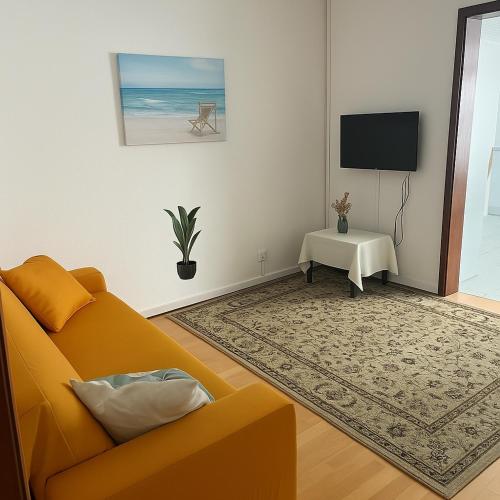 a living room with a couch and a television at Espaço perto aeroporto in Ponta Delgada