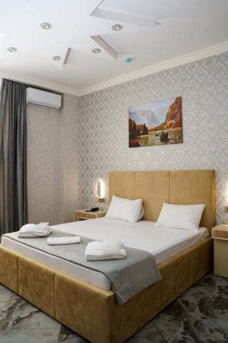 a bedroom with a large bed with white pillows at Kolizey Hotel Spa Ganja in Ganja