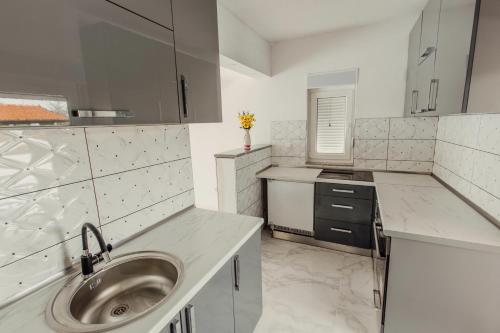 a white kitchen with a sink and a sink at Villa Deluxe Buna in Mostar