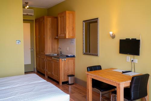 a room with a bed and a table and a sink at Hotel Beemster in Middenbeemster