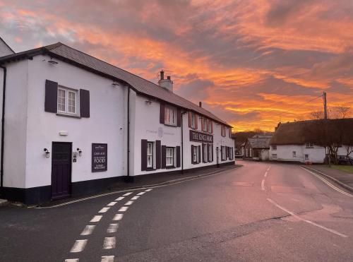 a white building on the side of a street at Small cottage in Stratton, Bude in Stratton