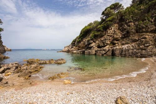 a beach with a rocky shore and the ocean at Relais Regina Giovanna in Sorrento