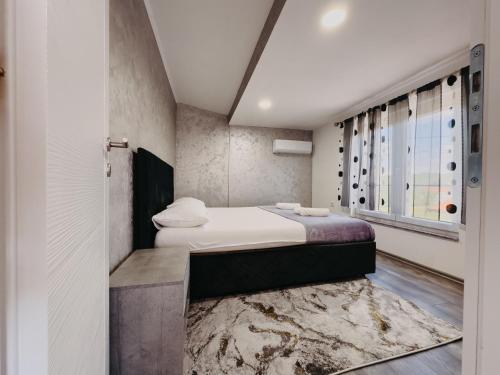 a bedroom with a bed and a rug at Villa Deluxe Buna in Mostar