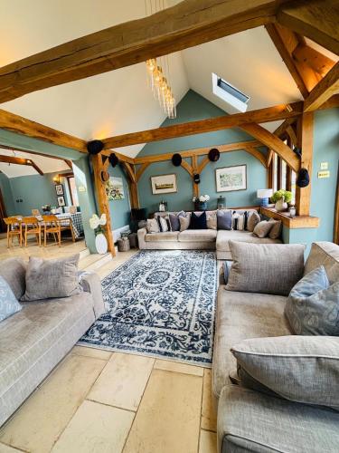 a living room with couches and a rug at Super Host Large Luxury Cottage South Downs Park in Lodsworth