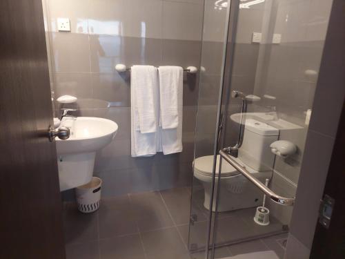 a bathroom with a toilet and a sink and a shower at Beach Front 2 by A & A Villas in Uswetakeiyawa