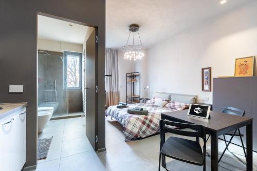 a kitchen and a living room with a bed and a table at Incantevole Appartamento in centro ad Alba in Alba