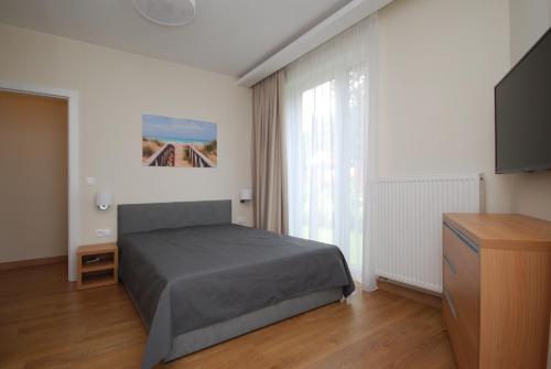 コンティ・リバツキエにあるLuksusowy Apartament Marinaのベッドルーム(ベッド1台、薄型テレビ付)