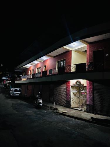 a building with a parking lot with a door on it at Aksha Inn in Madikeri