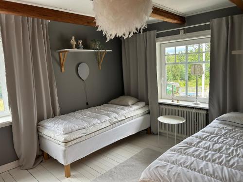 a bedroom with a bed and a window at Lev ut din Gårdsdröm! in Svängsta