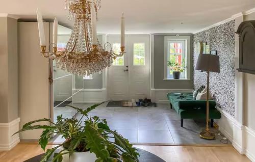 a living room with a chandelier and a green couch at Lev ut din Gårdsdröm! in Svängsta
