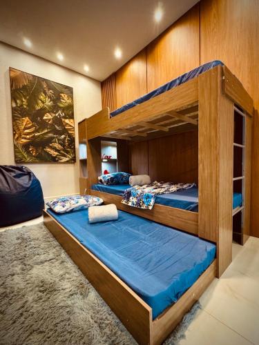 Ce dortoir comprend 2 lits superposés et des draps bleus. dans l'établissement Espaço LUHNA - Piscina - AR - Sauna Privativa, à Limeira