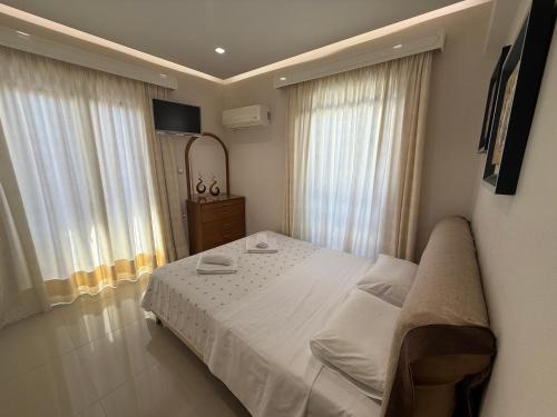 a bedroom with a large bed with white sheets at Anna's Seaside Apartment - In front of the beach in Kos Town