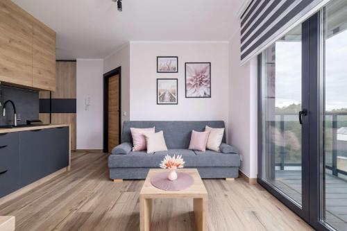 カトヴィツェにあるStylish Apartment with a Balcony Ideal for Remote Work by Noclegi Rentersのソファとテーブルのあるリビングルーム