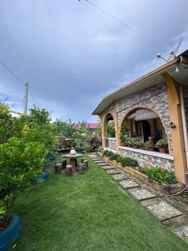 un jardin avec une table et un bâtiment dans l'établissement Subangan little Hawaii,6 Burgos Central location, à Burgos