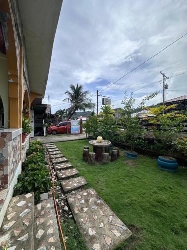 a backyard with a table and a grass yard at Subangan little Hawaii,6 Burgos Central location in Burgos