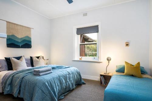 a bedroom with two beds and a window at Whistlewood - Stunning Views in the Adelaide Hills in Upper Sturt